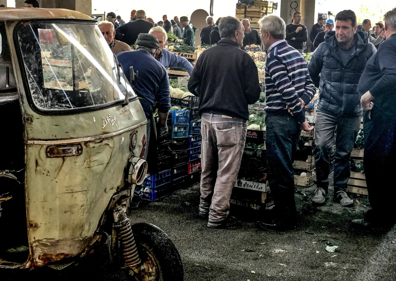 Un’Ape Piaggio d’epoca tra produttori e cassette al mercato ortofrutticolo