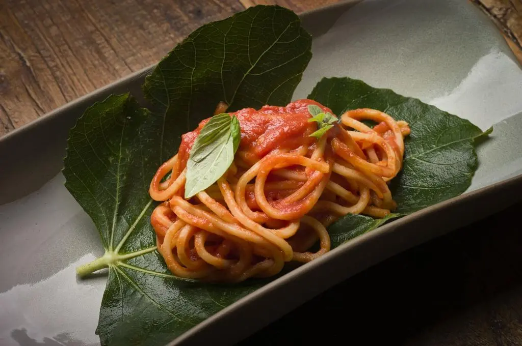 Spaghetti al pomodoro serviti su foglie di fico